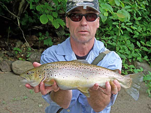 Ron Merly shows the size of the fish that can be caught on the annual Nutmeg TU camping trip along the Housatonic.